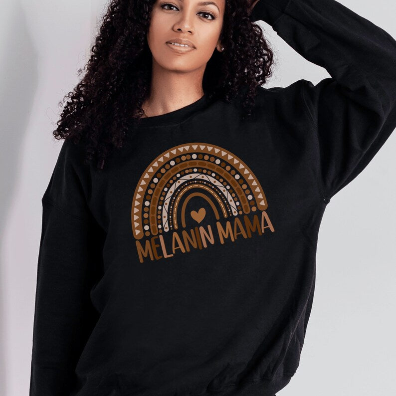 black  unisex melanin mom sweatshirt with a graphic of a rainbow in shades of brown with the words melanin mama underneath the rainbow