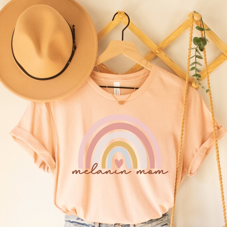 heather peach nisex melanin mom shirt with a rainbow that says melanin mom underneath