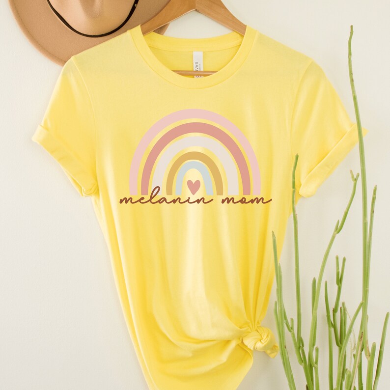 yellow nisex melanin mom shirt with a rainbow that says melanin mom underneath