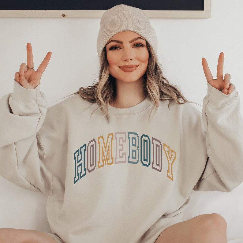 homebody sweatshirt, with the word homebody in multicolor lettering and college style font