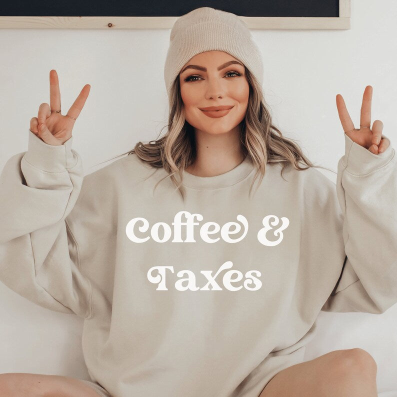 beige unisex gift for accountant graduate sweatshirt that says coffee & taxes