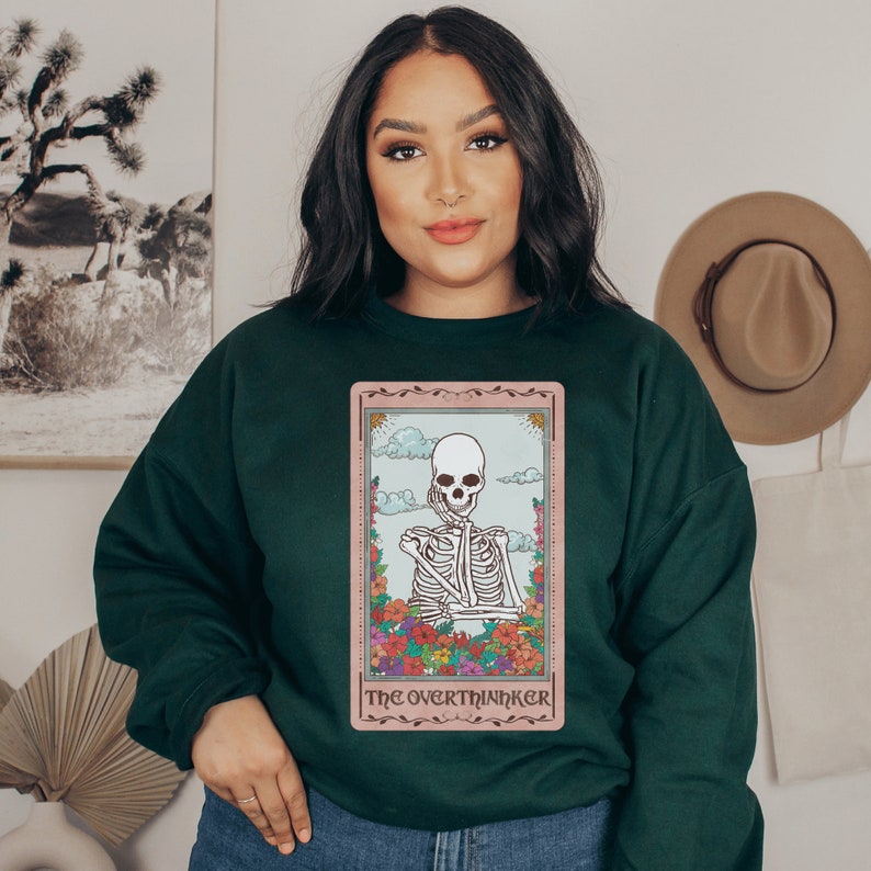 forest green unisex overthinker sweatshirt with a graphic of a tarot card with skeleton graphic that says the overthinker