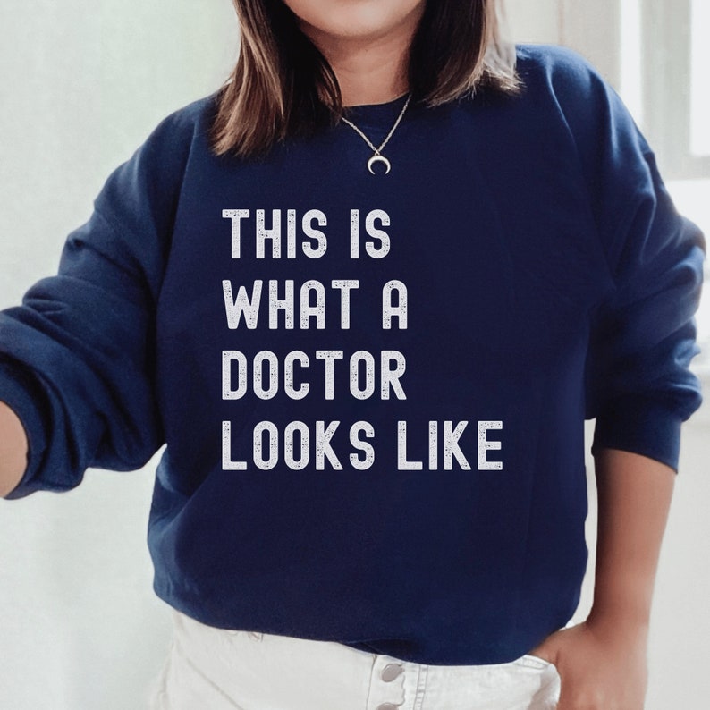 navy blue unisex graduation gift for phd; sweatshirt that says this is what a doctor looks like