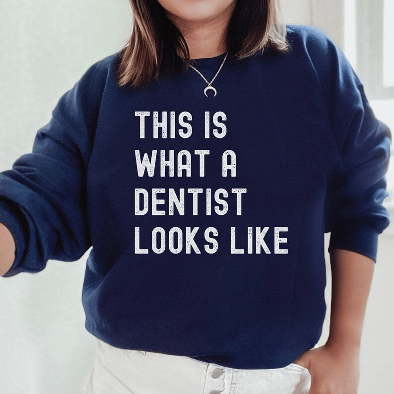 navy blue unisex dentist sweatshirt that says this is what a dentist looks like in all white, capital letters