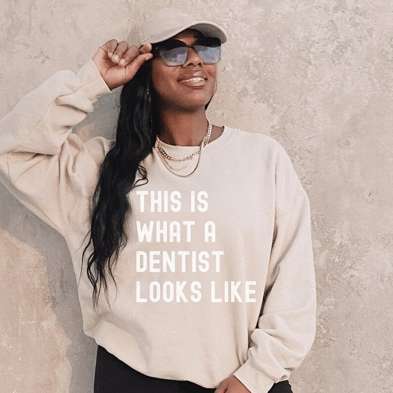 beige unisex dentist sweatshirt that says this is what a dentist looks like in all white, capital letters