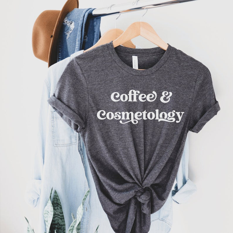 dark heather gray unisex t-shirt and cosmetology gift ideas that says coffee and cosmetology across the front in stylish font