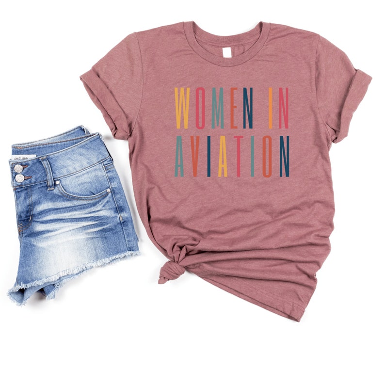 heather purple or plum colored unisex t-shirt with multicolored letters that say women in aviation