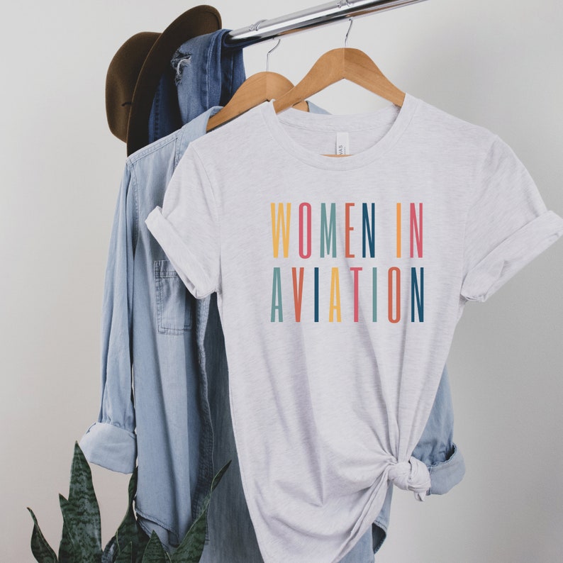 light gray or ash unisex t-shirt with multicolored letters that say women in aviation