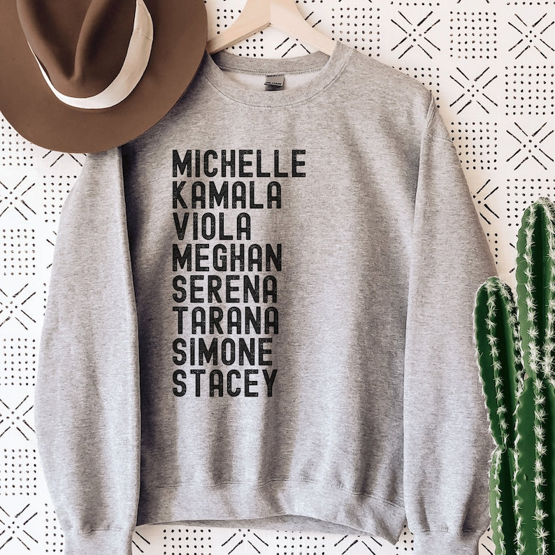 gray unisex melanin sweatshirt that says michelle, kamala, viola, meghan, serena, tarana, simone, stacey in all black capital letters