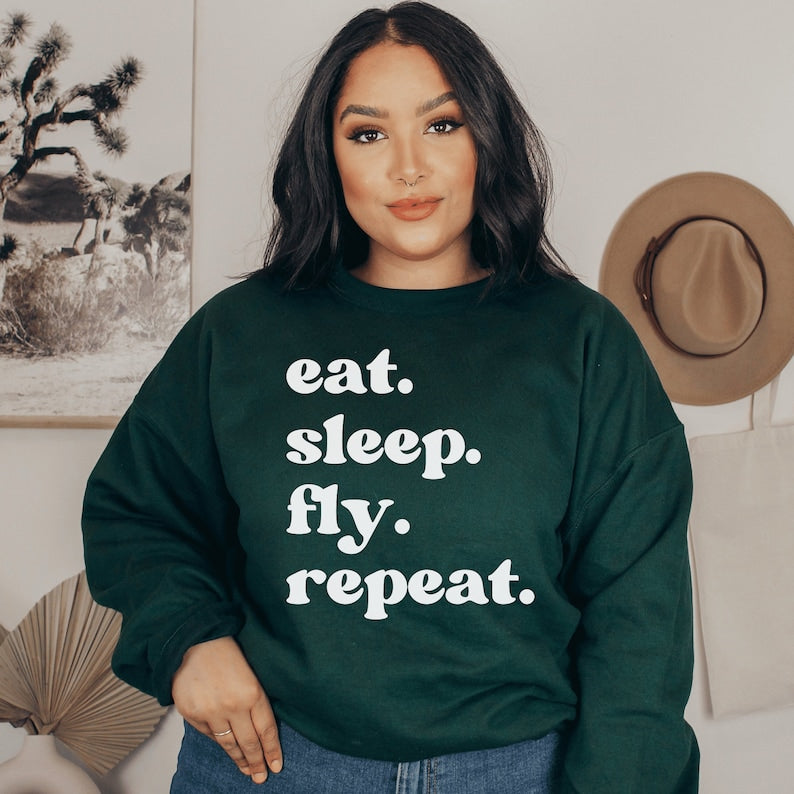 forest green unisex wanderlust sweatshirt that says eat sleep fly repeat
