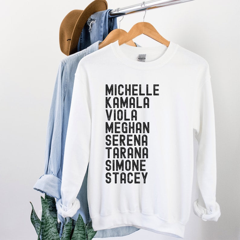 white unisex melanin sweatshirt that says michelle, kamala, viola, meghan, serena, tarana, simone, stacey in all black capital letters