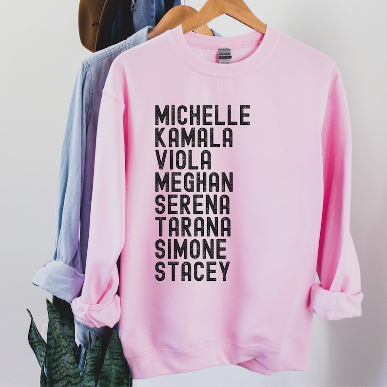 pink unisex melanin sweatshirt that says michelle, kamala, viola, meghan, serena, tarana, simone, stacey in all black capital letters