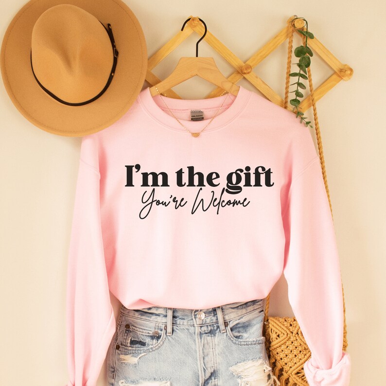 pink unisex sassy sweatshirt that says i'm the gift you're welcome in black lettering