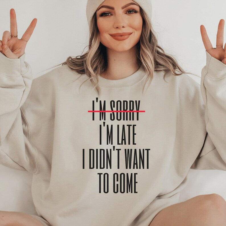 beige unisex introvert sweatshirts that say im sorry im late i didnt want to come with the words im sorry crossed out with a red line