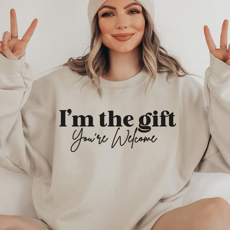 beige unisex sassy sweatshirt that says i'm the gift you're welcome in black lettering