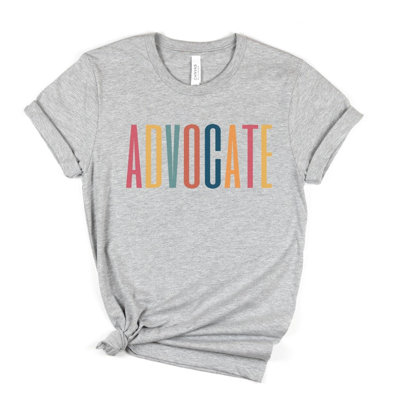 gray unisex t-shirt that says the word "advocate" in capital, multicolored letters