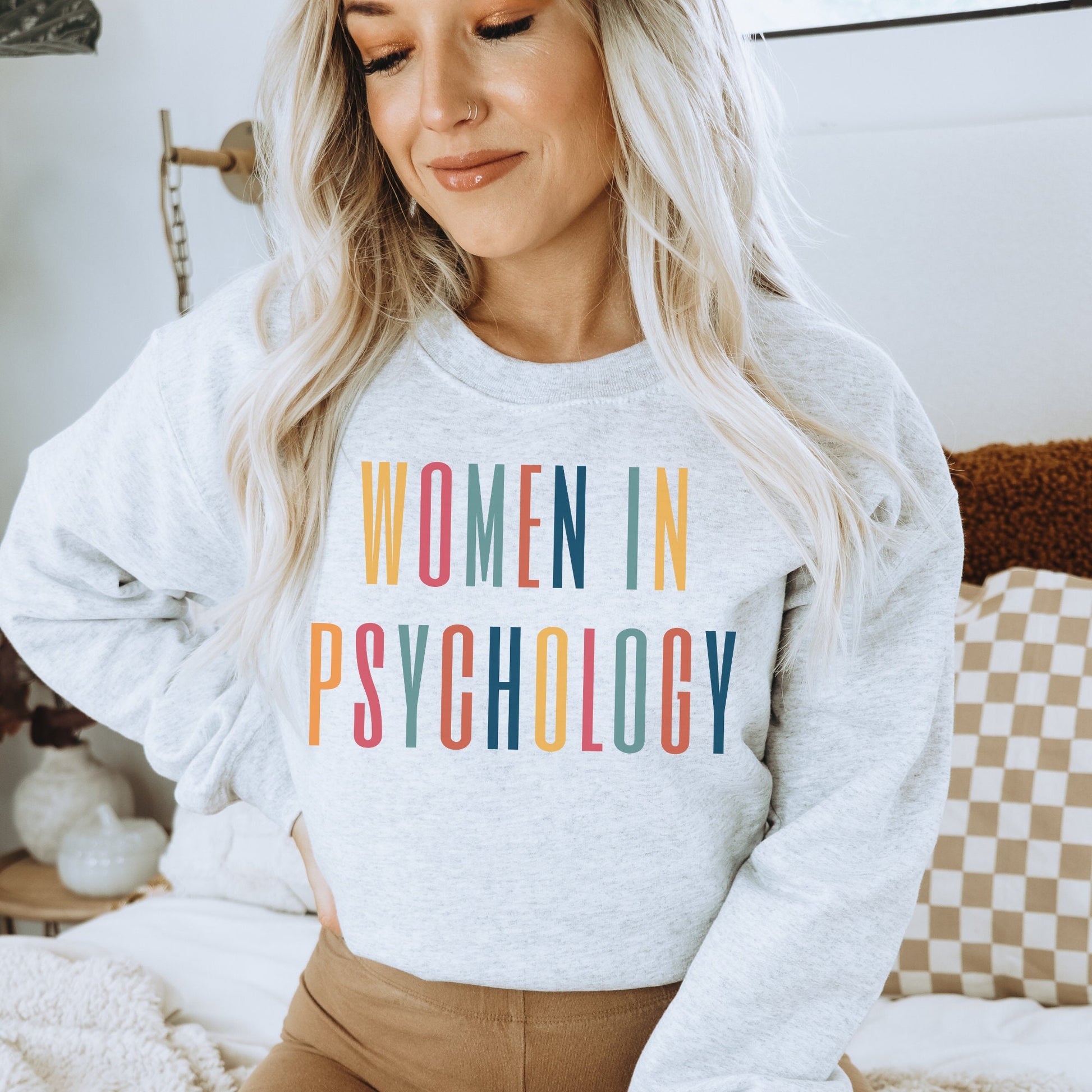 light gray unisex psych sweatshirt that says "women in psychology" in all capital, multicolored letters