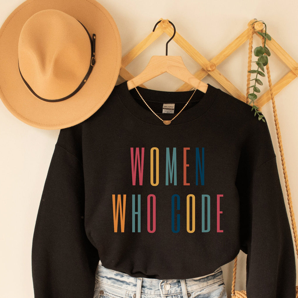 black unisex coder sweater that says "women who code" in all capital, multicolor letters