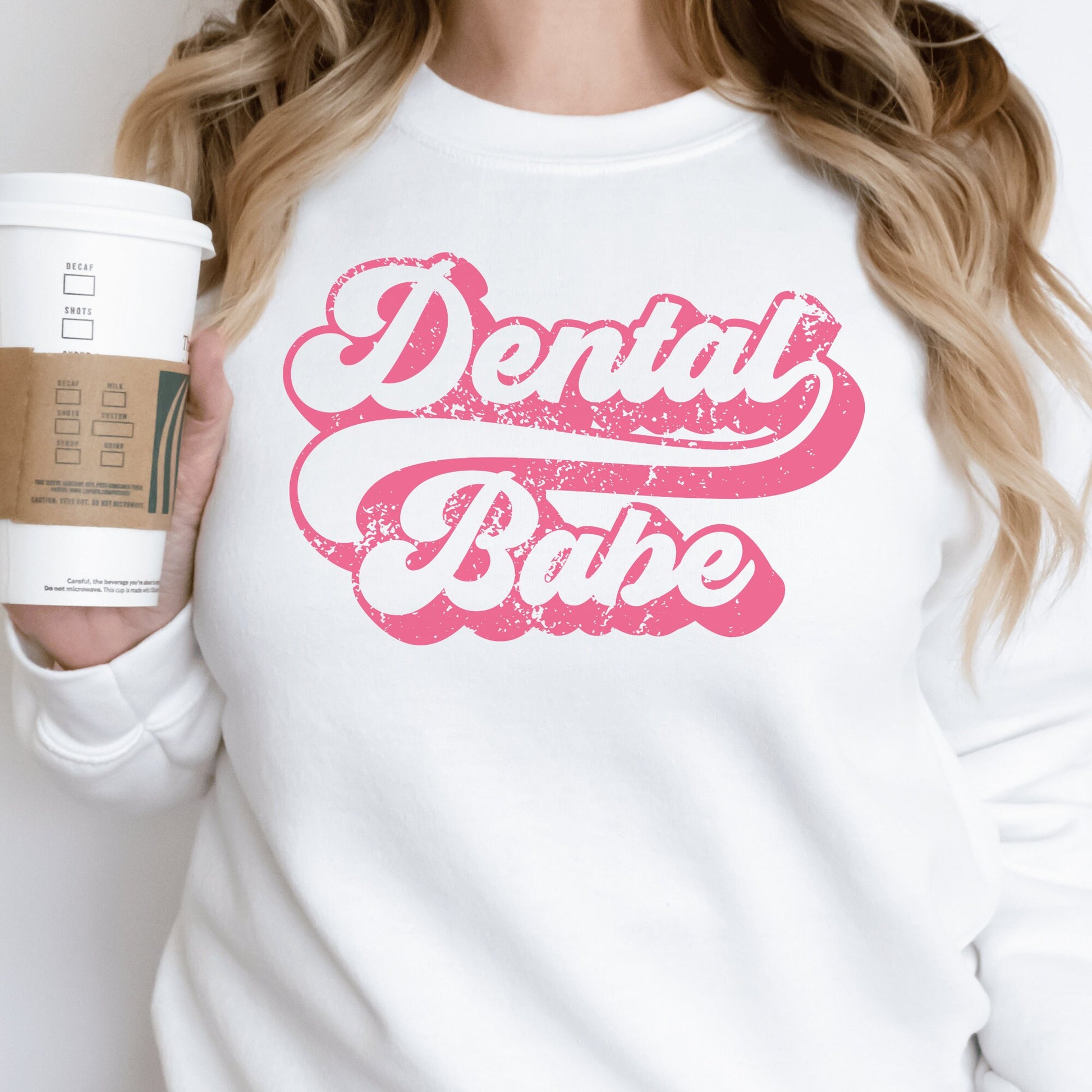 white unisex dental hygienist sweatshirt that says "dental babe" in retro styled pink lettering with an antique and vintage style