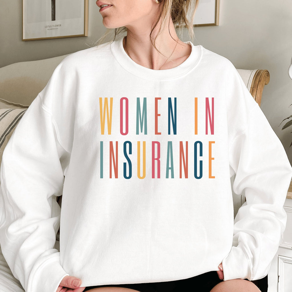 white unisex sweatshirt that says "women in insurance" in all capital, multicolored letters and makes the perfect gift for an insurance agent