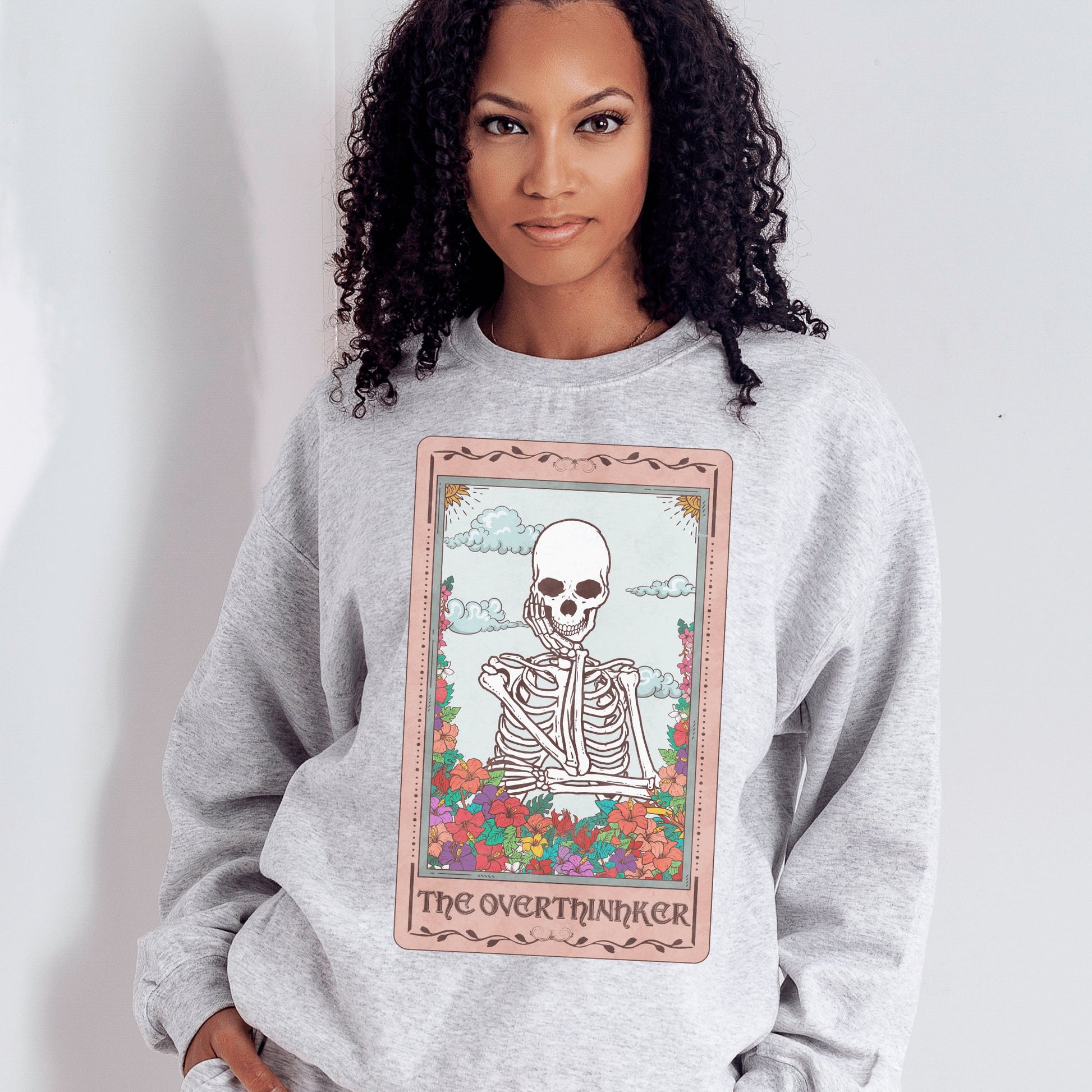 light gray unisex overthinker sweatshirt with a graphic of a tarot card with skeleton graphic that says the overthinker