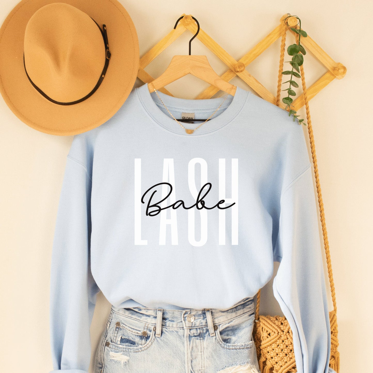 light blue  unisex sweatshirt lash tech gift that says lash in white capital letters and the word babe across in black cursive font