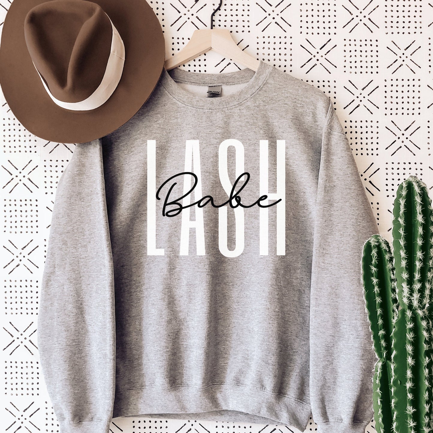 gray  unisex sweatshirt lash tech gift that says lash in white capital letters and the word babe across in black cursive font