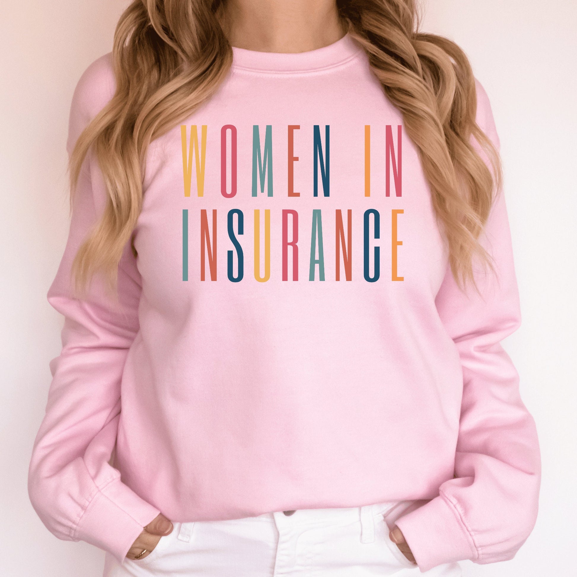 pink unisex sweatshirt that says "women in insurance" in all capital, multicolored letters and makes the perfect gift for an insurance agent