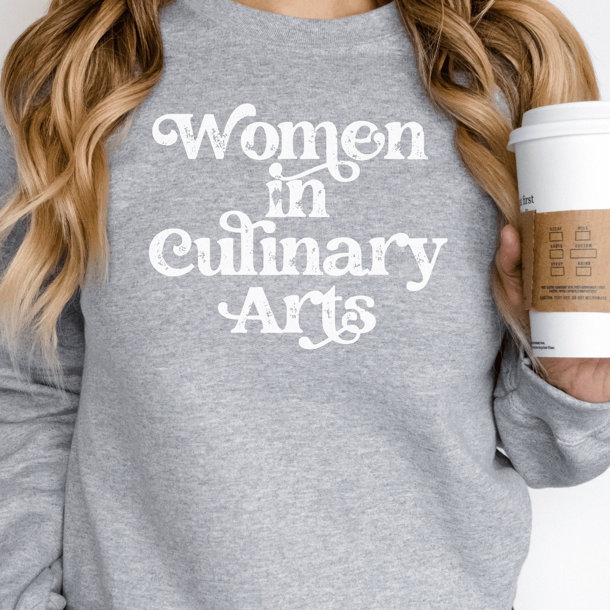 gray unisex sweatshirt that says women in culinary arts in white letters with a whimsical font; perfect gift for culinary students