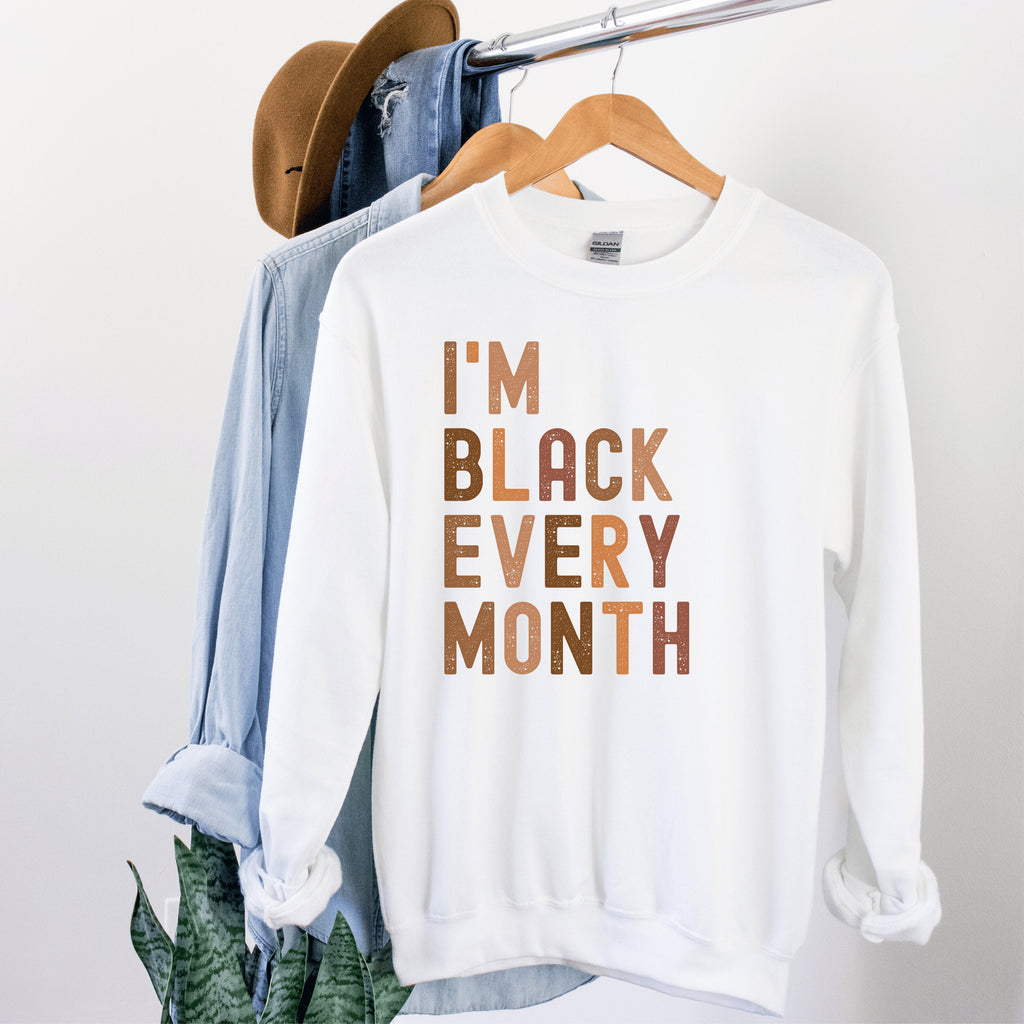 white Beige unisex I am black every month shirt, with the words written in all capital, multicolored shades of brown 