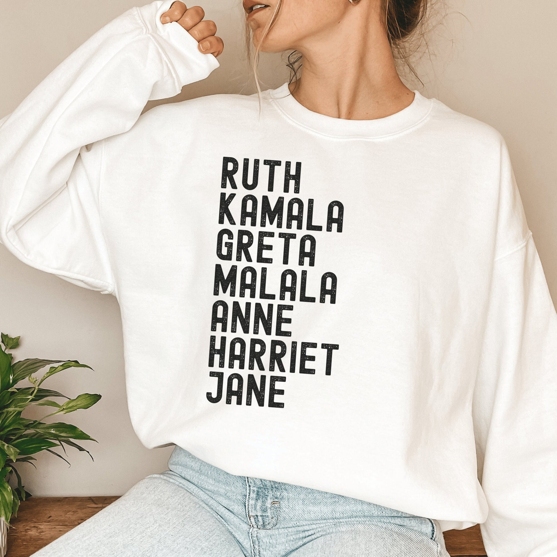 white unisex women empowerment sweatshirt that says ruth, kamala, greta, malala, anne, harriet, jane in all black capital letters