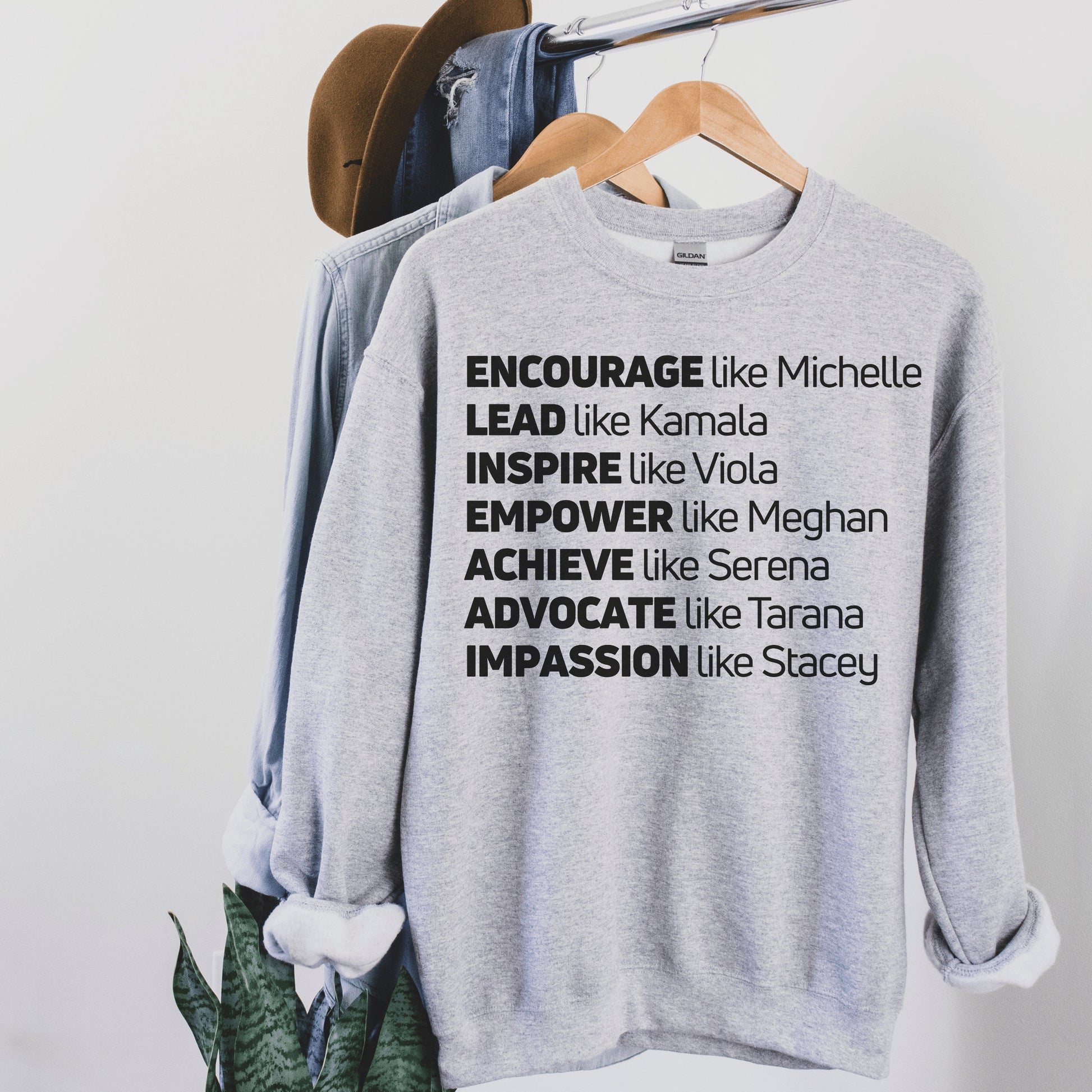 gray unisex melanin sweatshirt that says encourage like michelle, lead like kamala, inspire like viola, empower like meghan, achieve like serena, advocate like tarana, impassion like stacey