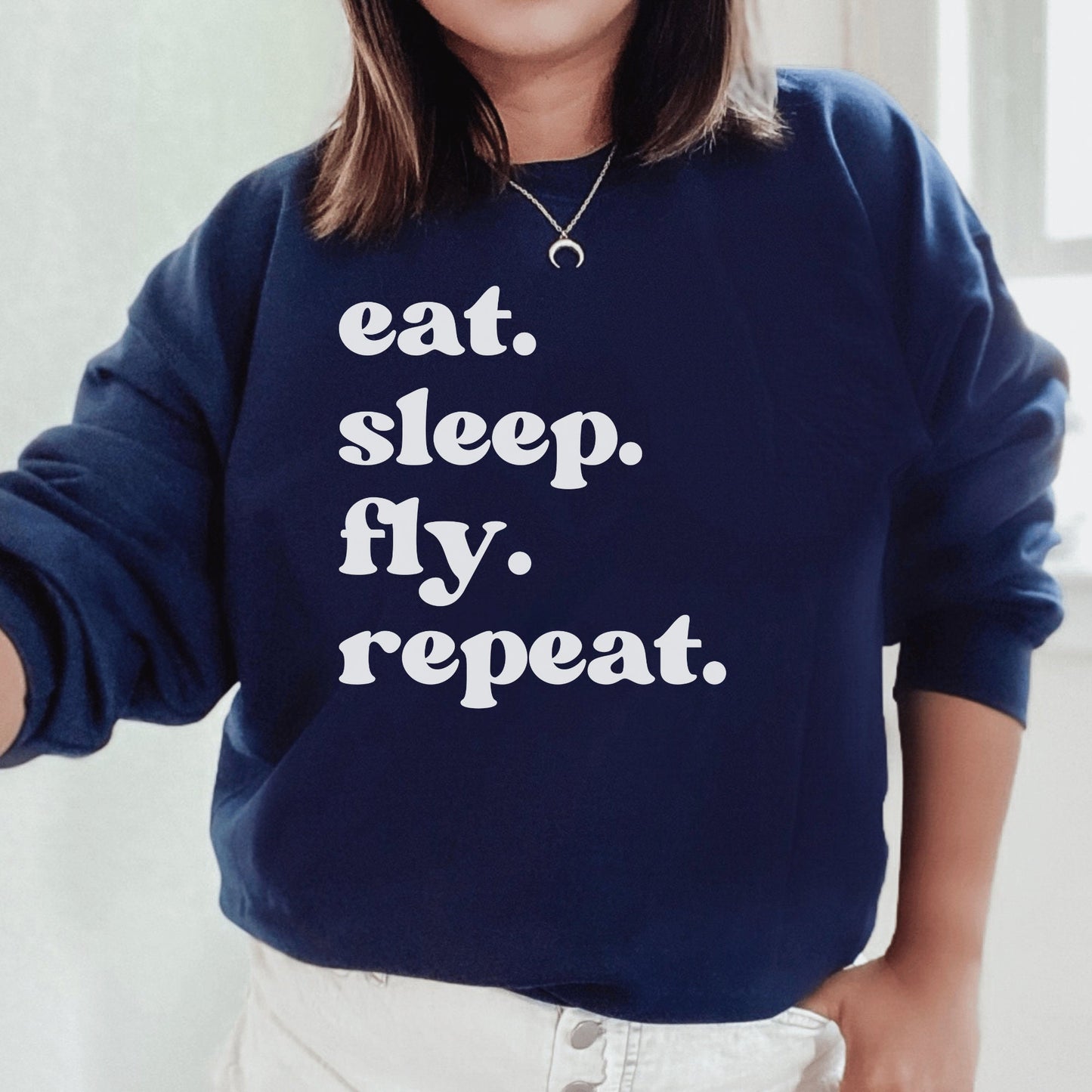 navy unisex wanderlust sweatshirt that says eat sleep fly repeat
