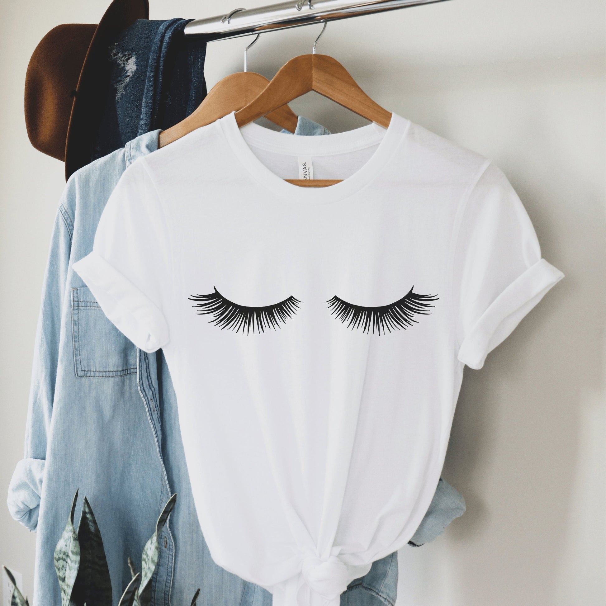 white unisex lashes tshirt with a graphic of black lashes