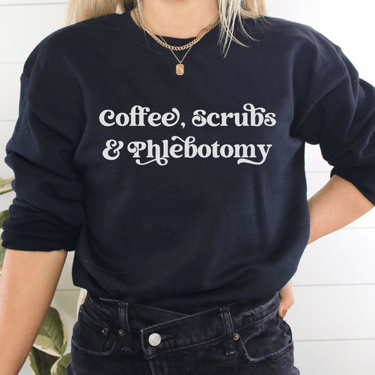 our gifts for a phlebotomist include this black unisex sweatshirt that says coffee, scrubs, & phlebotomy