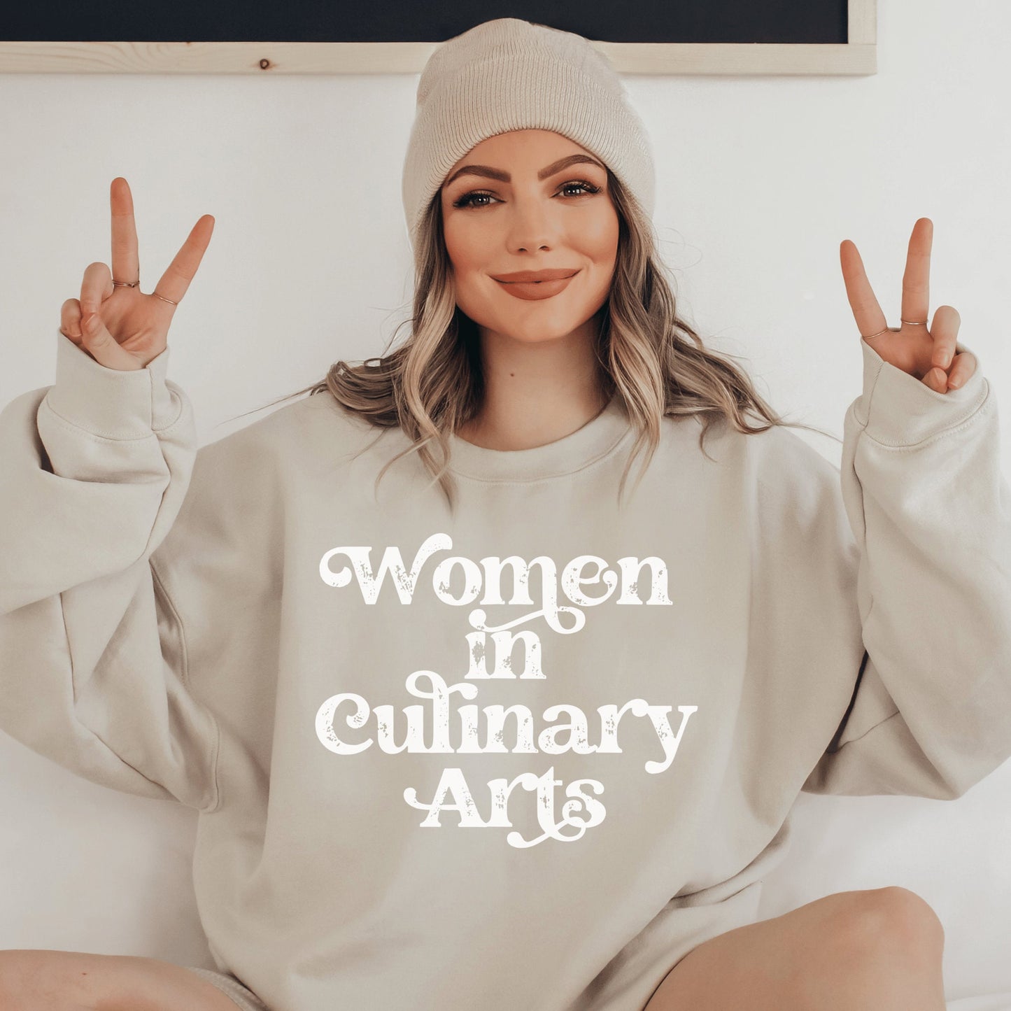 beige unisex sweatshirt that says women in culinary arts in white letters with a whimsical font; perfect gift for culinary students