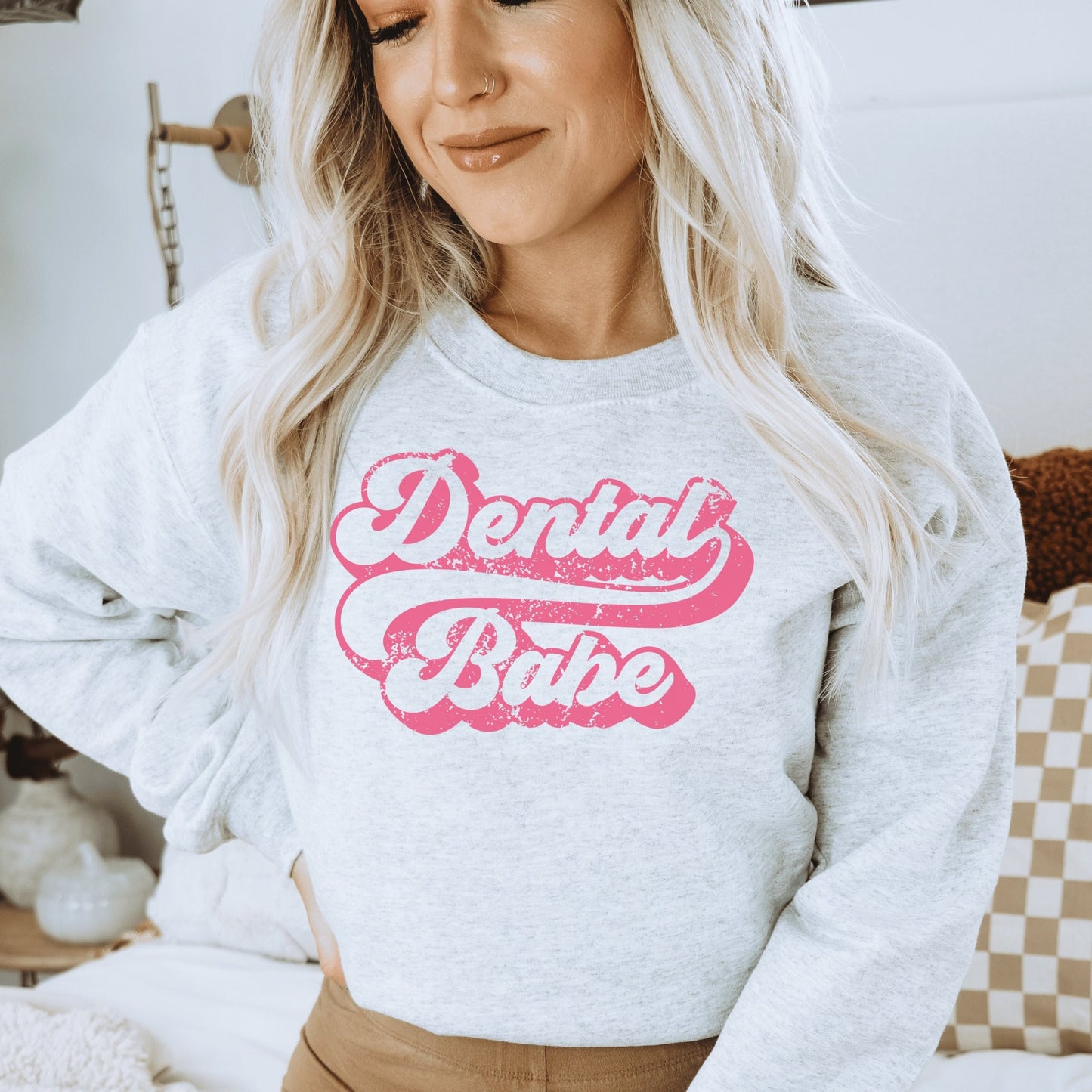 light gray unisex dental hygienist sweatshirt that says "dental babe" in retro styled pink lettering with an antique and vintage style