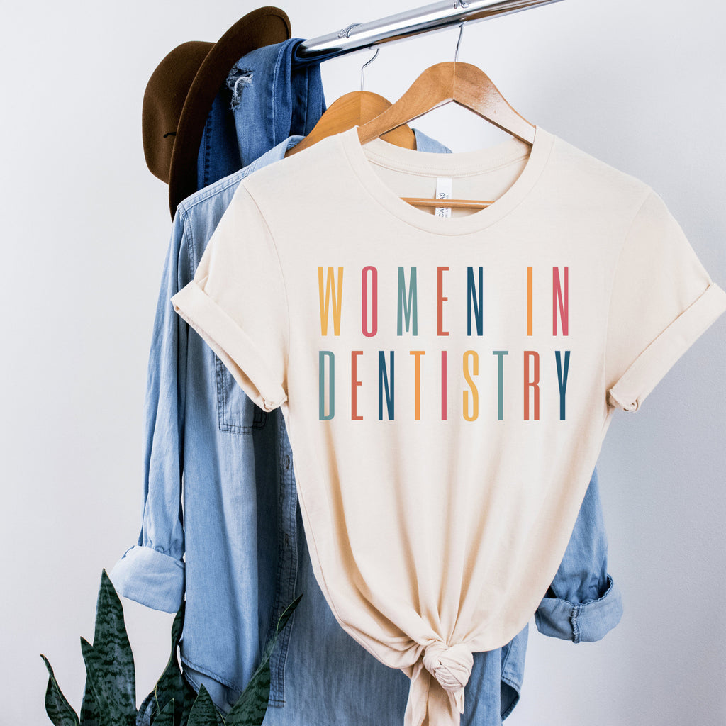 soft cream unisex dental shirt that says women in dentistry in all capital multicolored letters, perfect graduation gift for dentists