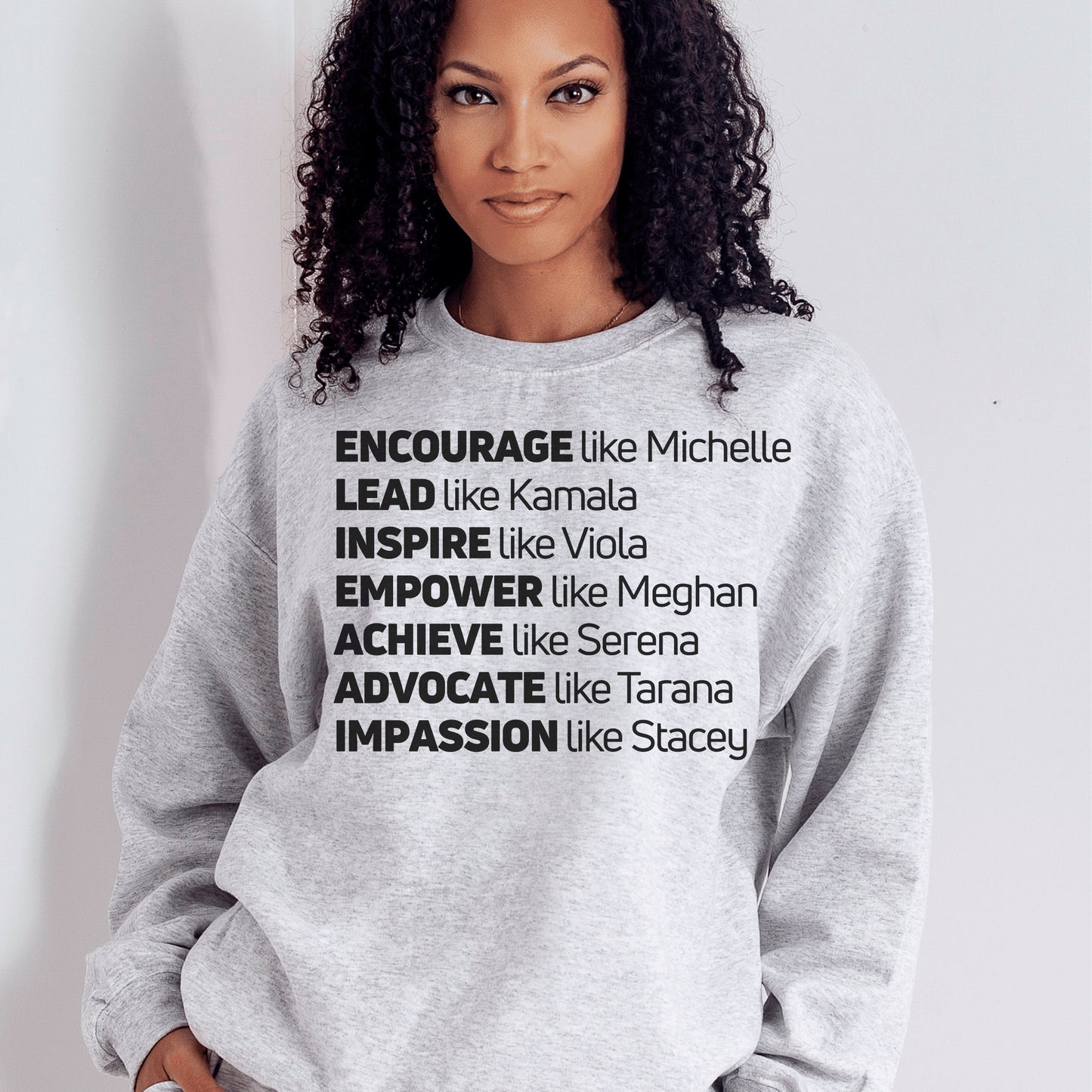 light gray unisex melanin sweatshirt that says encourage like michelle, lead like kamala, inspire like viola, empower like meghan, achieve like serena, advocate like tarana, impassion like stacey