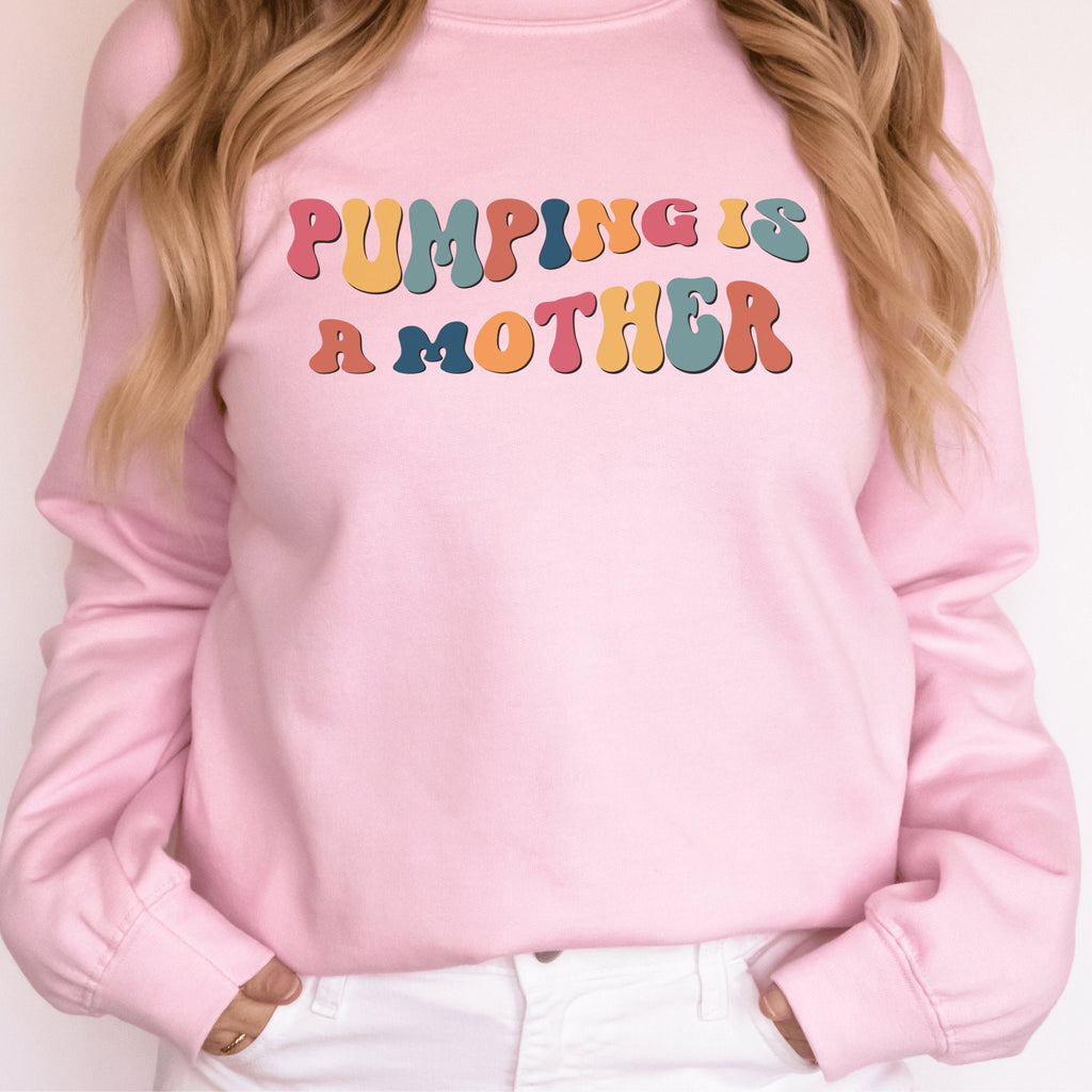 pink unisex gifts for pumping moms, this sweatshirt says pumping is a mother in retro mutlicolored font