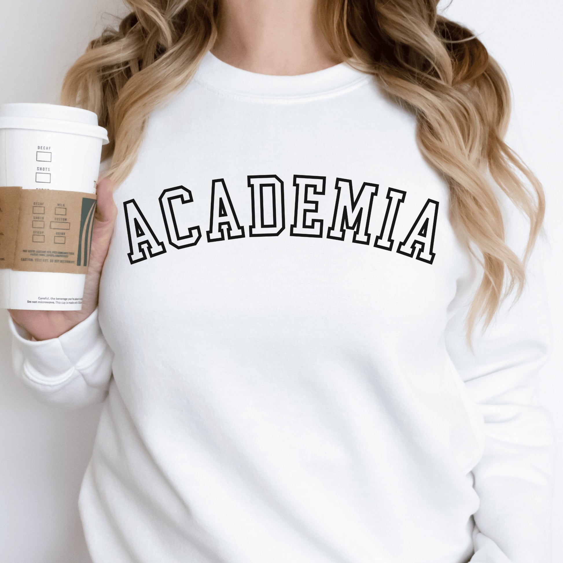 professor gifts, white unisex sweatshirt on a female model that says Academia across the front in college style black letters