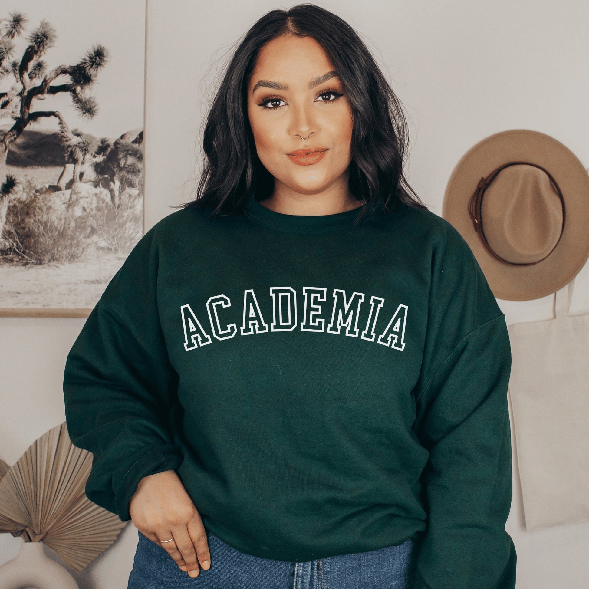 professor gifts, forest green unisex sweatshirt on a female model that says Academia across the front in college style white letters