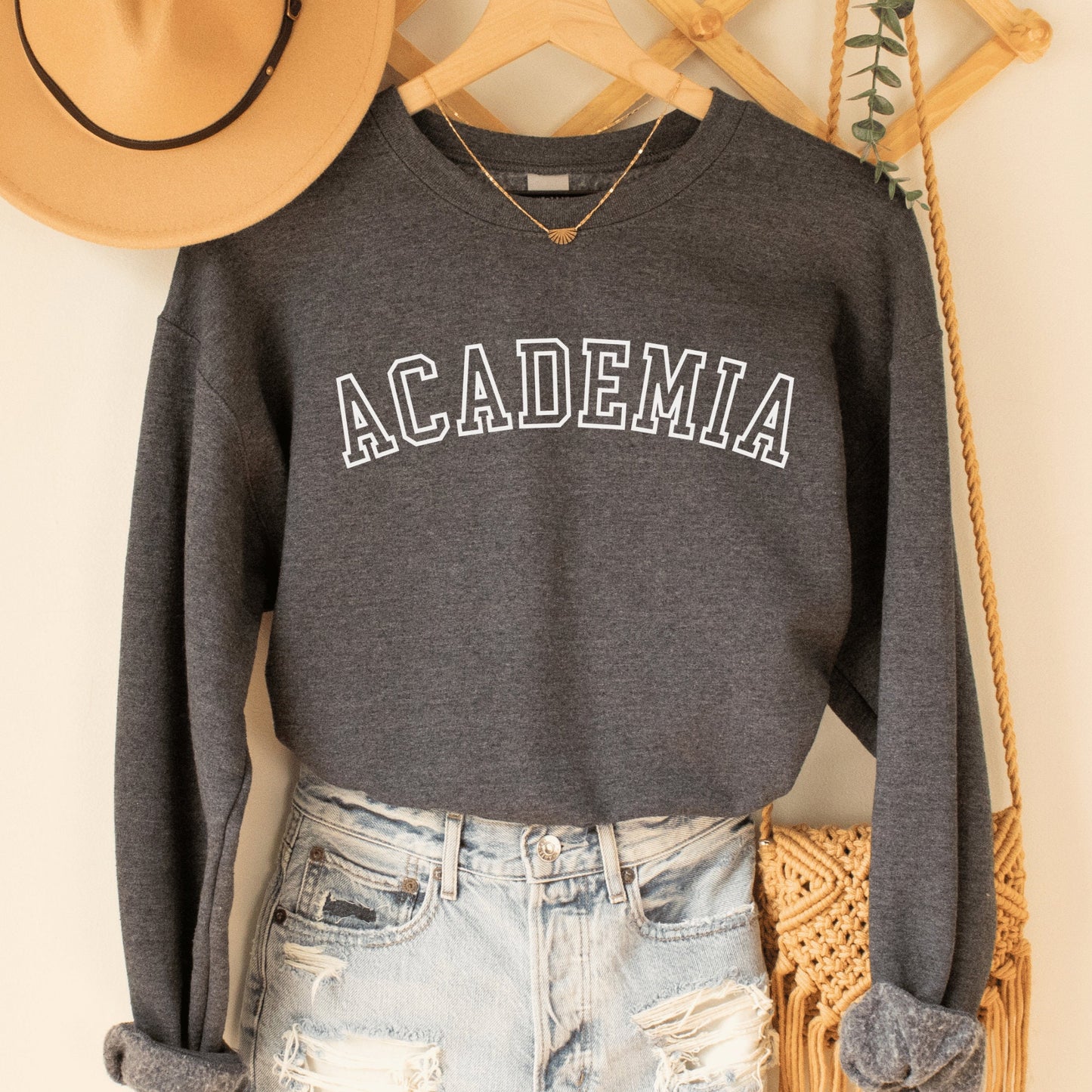 professor gifts, dark heather gray unisex sweatshirt on a female model that says Academia across the front in college style white letters