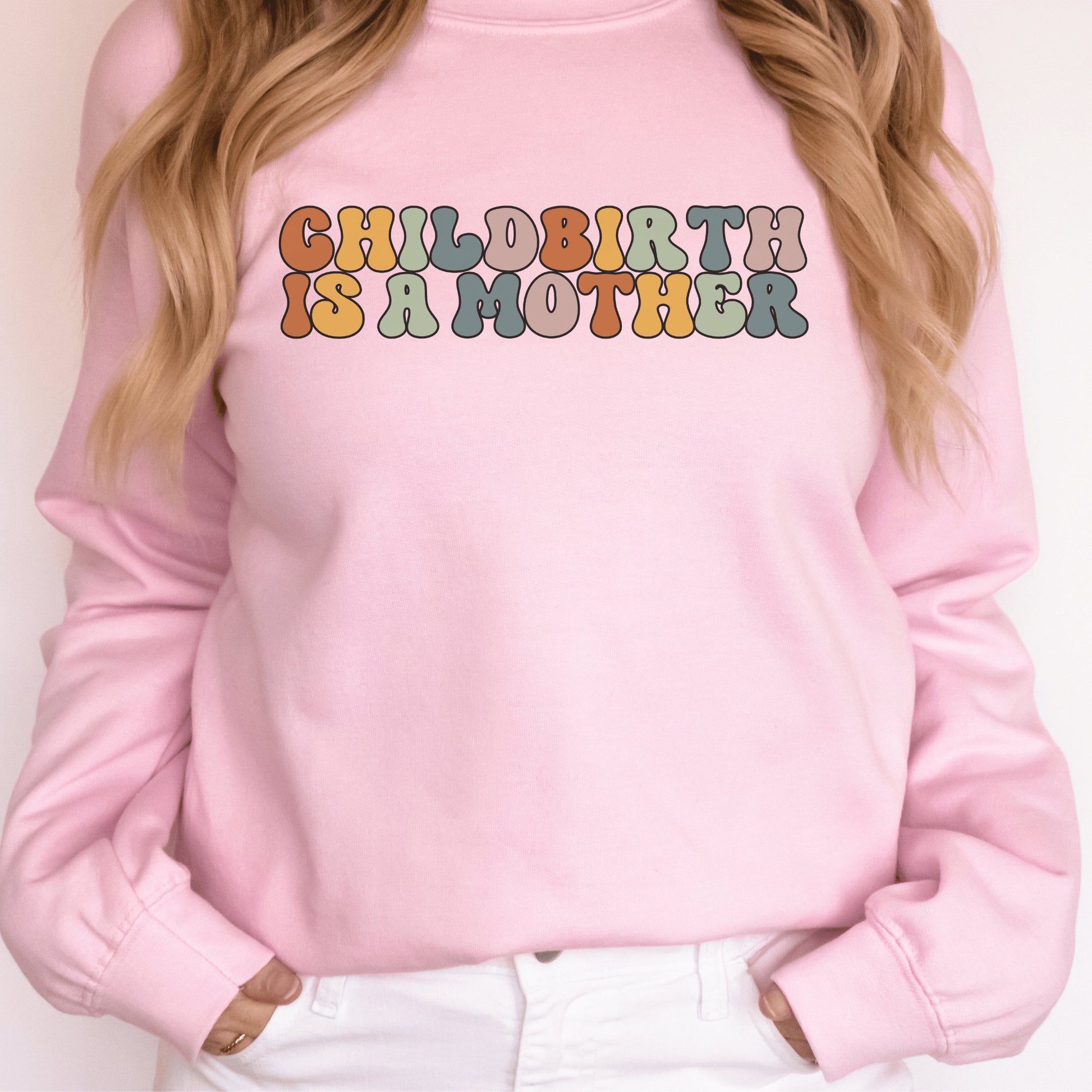 pink unisex motherhood sweatshirt that says "childbirth is a mother" in retro styled multicolored all capital letters