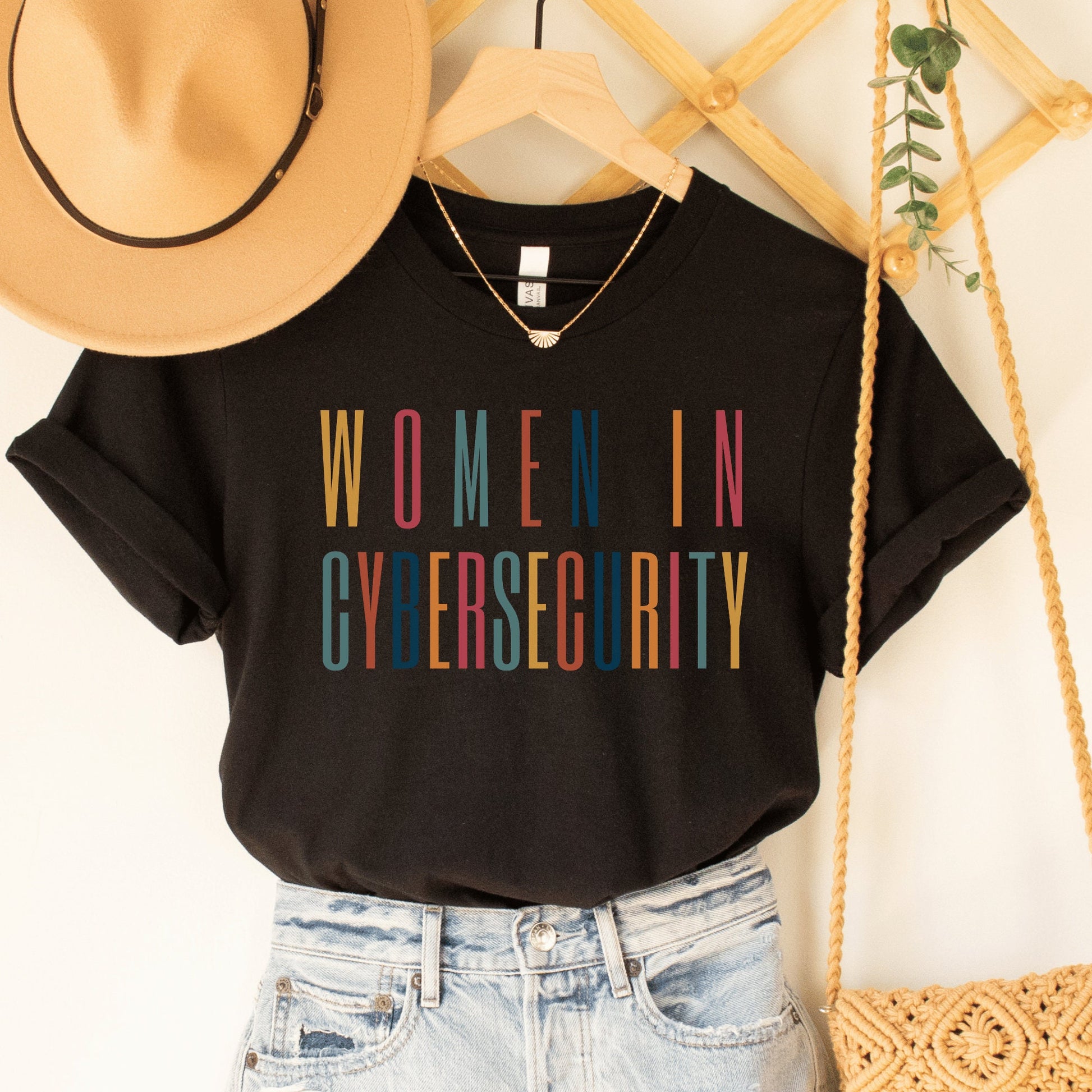 black unisex t-shirt that says women in cybersecurity in all capital, multicolored letters, this is a cyber security gift idea