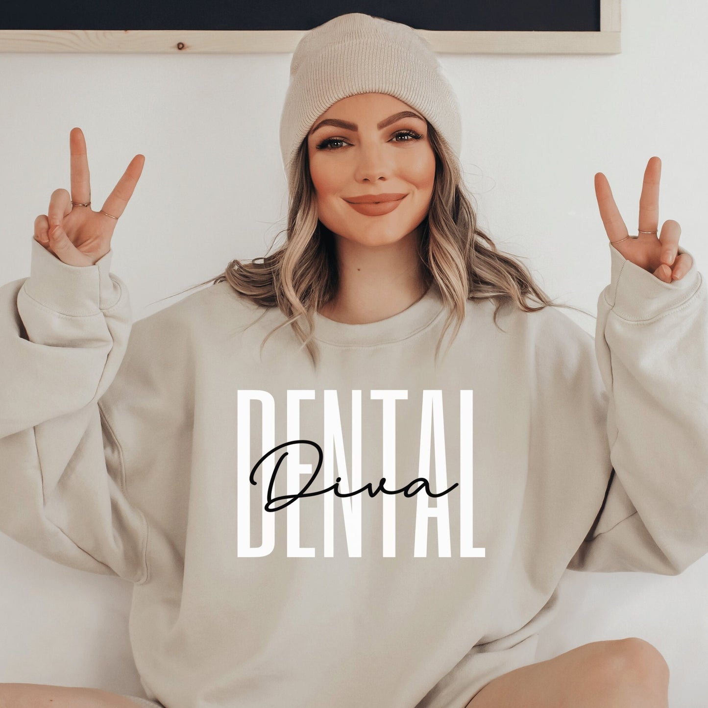 beige unisex dental hygienist sweatshirt that says dental in all white capital letters with the word diva in black script overlaying the word dental