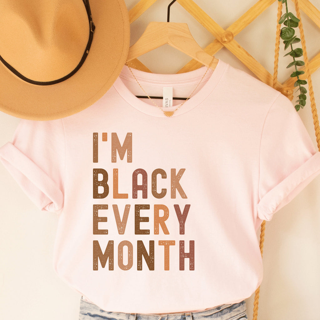 pink unisex "i am black every month" shirt with lettering in all capital, multicolored shades of brown