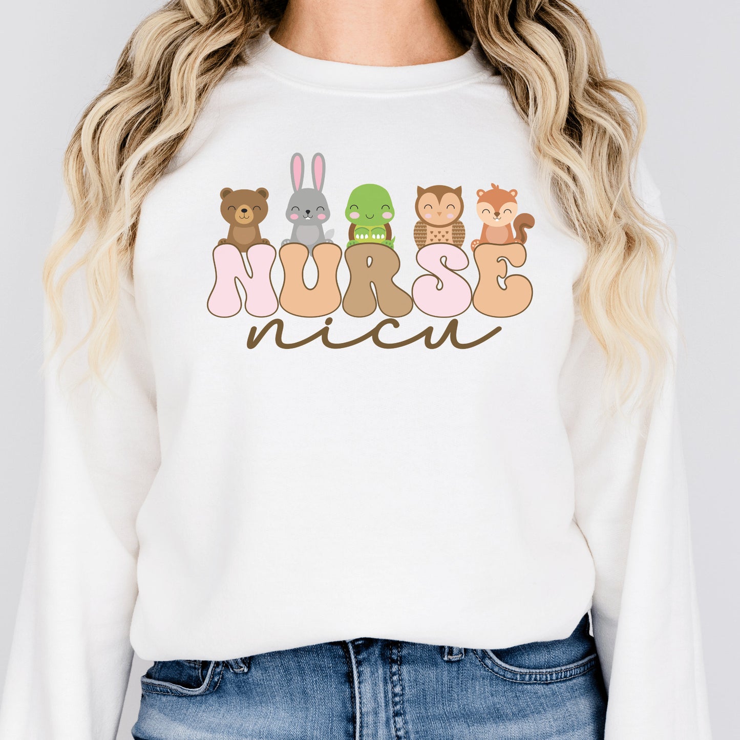 white unisex nicu nurse sweatshirt with nurse in retro capital multicolored letters and the word nicu in brown script underneath. Baby animals are on top of the word nurse