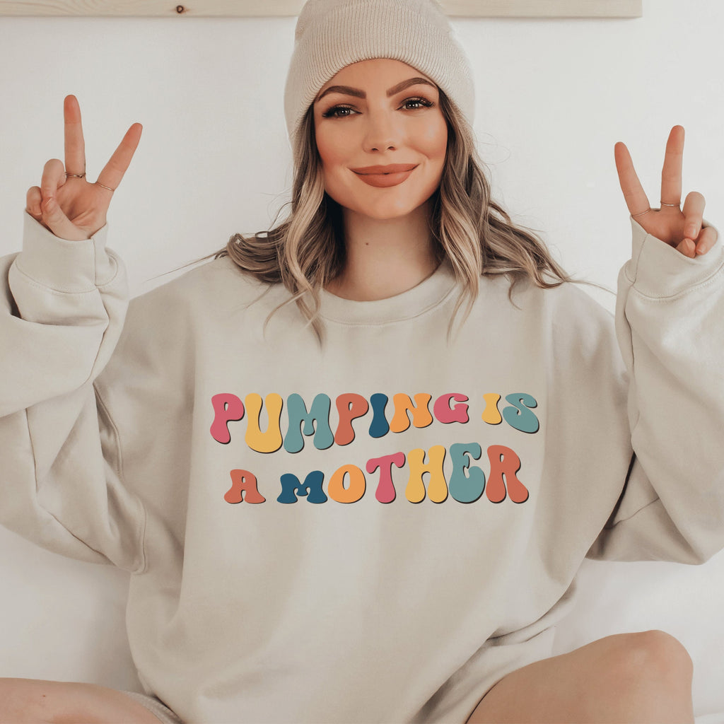beige unisex gifts for pumping moms, this sweatshirt says pumping is a mother in retro mutlicolored font